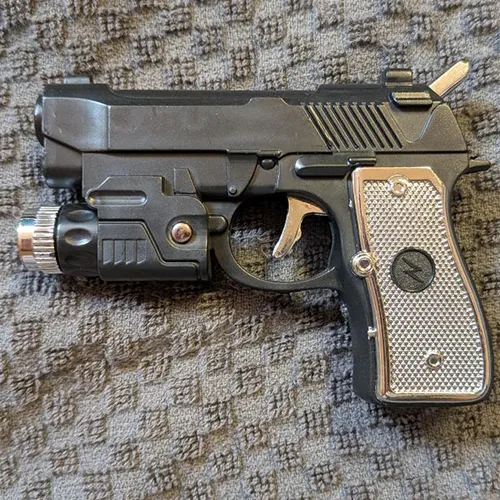 Novelty refillable gas lighter in the shape of a pistol, equipped with an additional electric-shock function and without a child-resistant safety mechanism, sold in bulk.