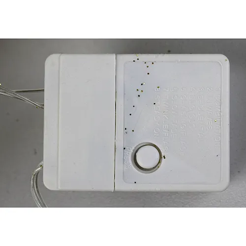 Decorative luminaire in the shape of a reindeer with yellow LED lights, gold-coloured glitter body, transparent insulated wires, and a white electronic controller box marked EK-04. Product is supplied with a cord extension set.