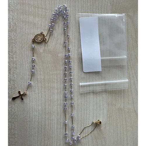 Rosary necklace with violet-coloured beads, a round metal pendant, and a metal cross, sold in bulk