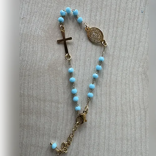 Rosary bracelet with turquoise-coloured beads, a round metal pendant, and a metal cross, sold in bulk.