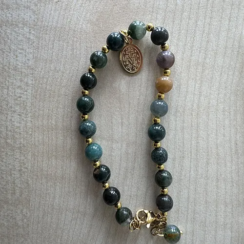 Rosary Bracelet with green- and blue-coloured beads and a round metal pendant in between the beads, sold in bulk.