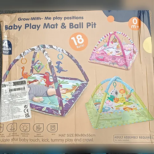 Activity play mat intended for babies with figurines in the shape of animals hanging from a bow above the mat.