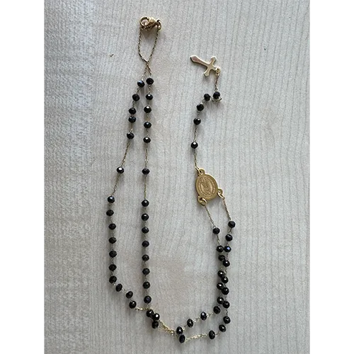 Set of rosary necklace with black-coloured beads, a round metal pendant and a metal cross.