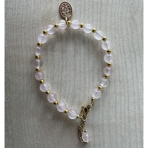 Rosary bracelet with pink-coloured beads and a round metal pendant.