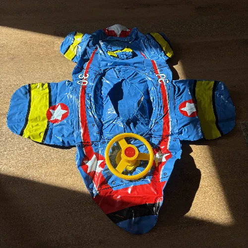 Blue inflatable swim seat in the shape of an aeroplane with a steering wheel