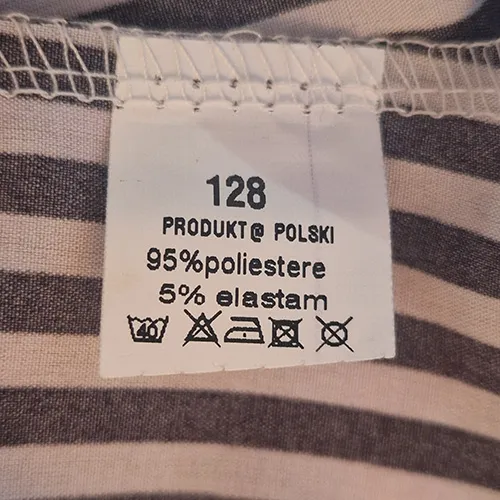 Black and white striped dress, intended for children, with short sleeves, a round neck with a decorative front tie, an elasticated waist, and a tiered skirt. Size 128.