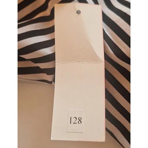 Black and white striped dress, intended for children, with short sleeves, a round neck with a decorative front tie, an elasticated waist, and a tiered skirt. Size 128.