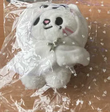 Soft toy keyring in the shape of a white cat with a metal chain, wearing a hooded cape with a small bow-shaped button.