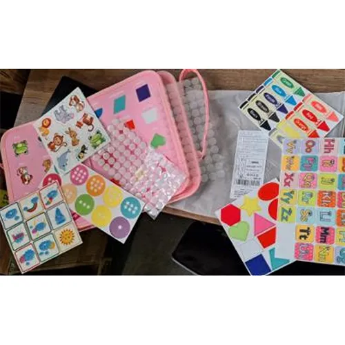 Pink busy board with stickers and accessories.